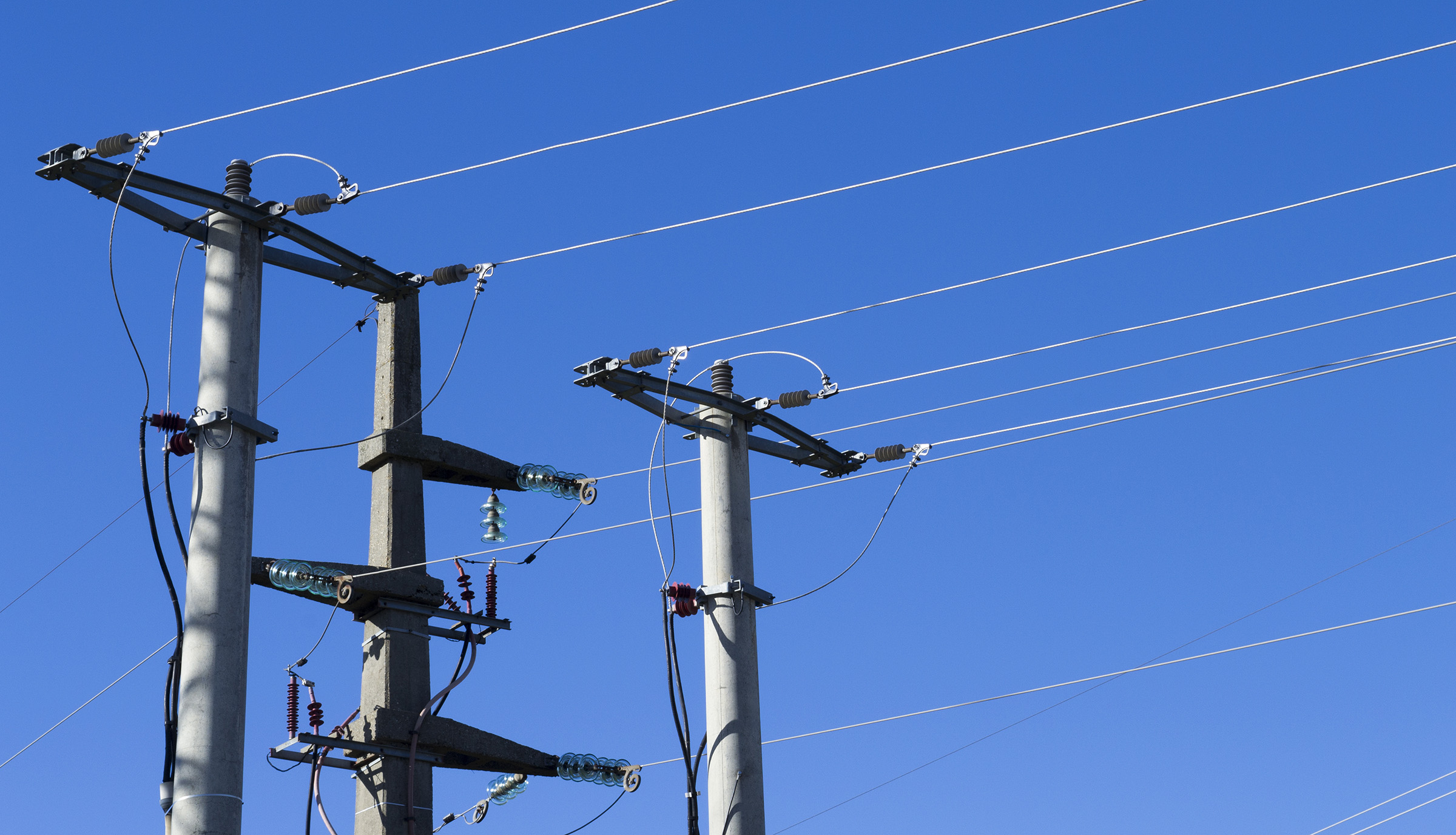 shot electric-posts-lines-against-blue-background